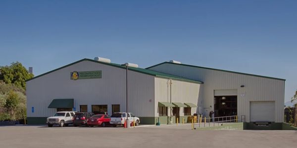 Large metal building with office building placed in front of a larger warehouse behind the office