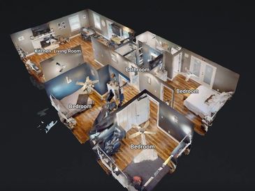3D floor plan showing a house with three bedrooms, a kitchen/living room, and a bathroom.