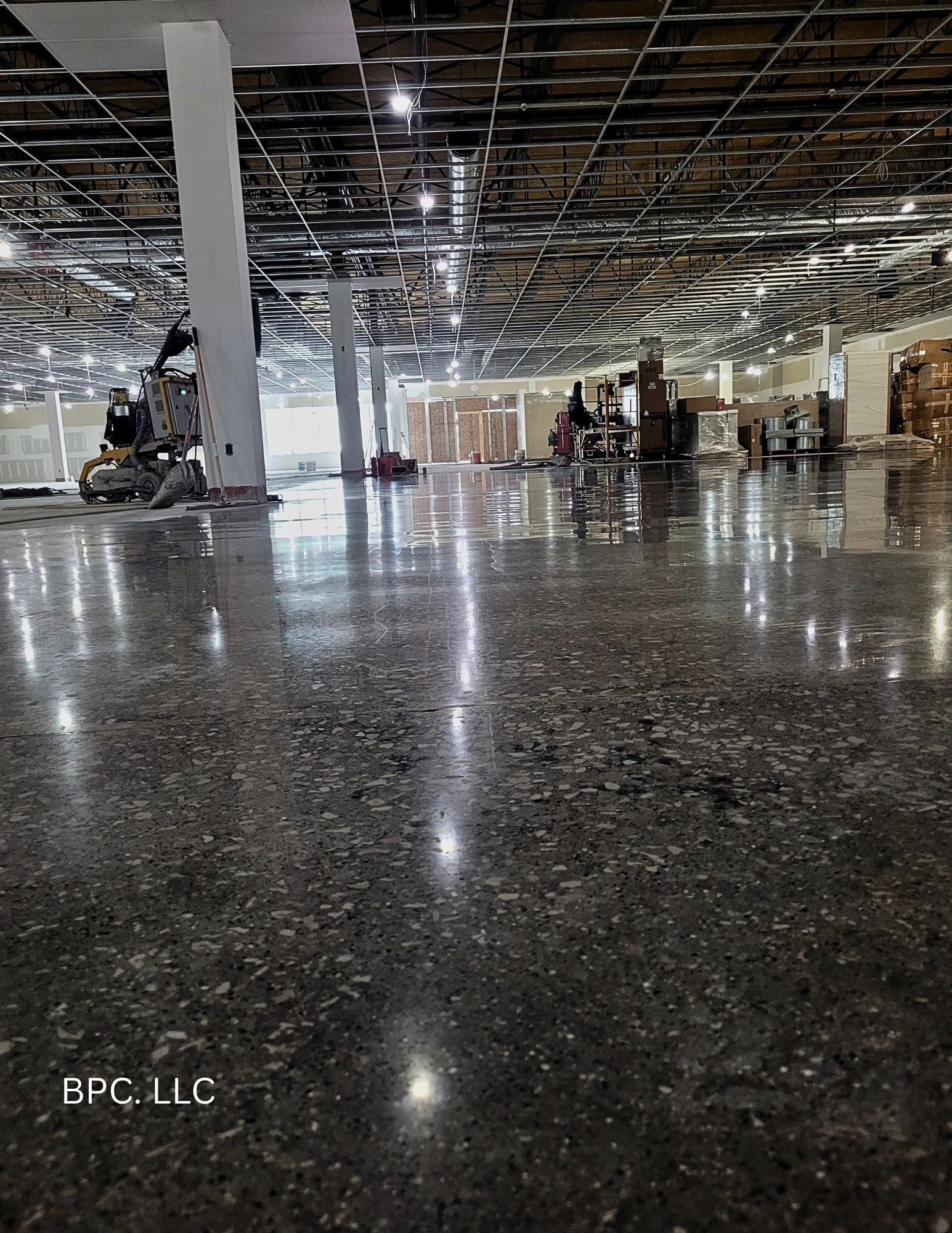 Polished concrete floor in a large industrial space under construction.