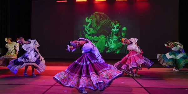 Folkloric dancers performing in colorful traditional dresses during a Casa Azul cultural event.