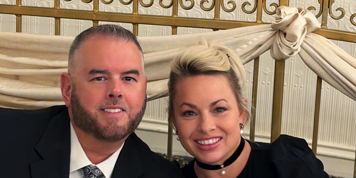 Smiling couple dressed formally for an event.