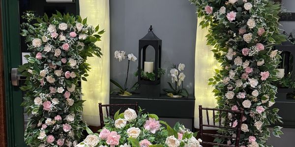 Two piece wood flower arch with table and flowers in front in white and pink