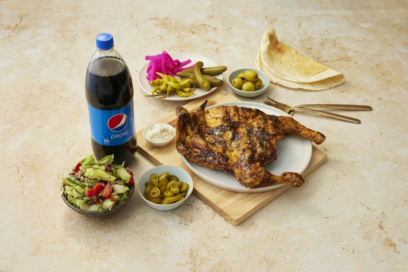 A charcoal chicken family feast with sides, ready for a crowd