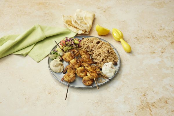Grilled prawns with rice, hummus, garlic sauce and salad