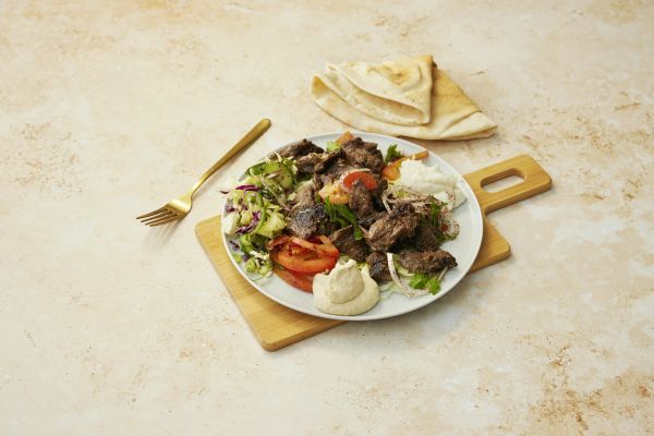 Homemade lamb shawarma with hummus, garlic sauce, Lebanese salad and bread