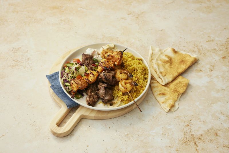 A spread of grilled platters, charcoal chicken, mezze and salads