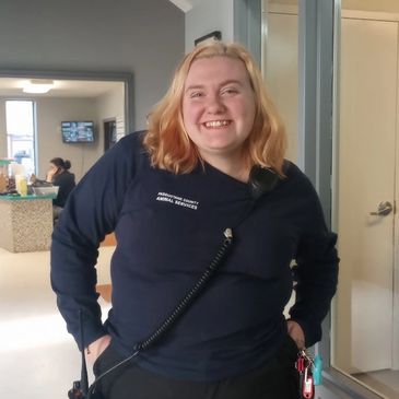 Smiling woman in Pasquotank County Animal Services uniform indoors.