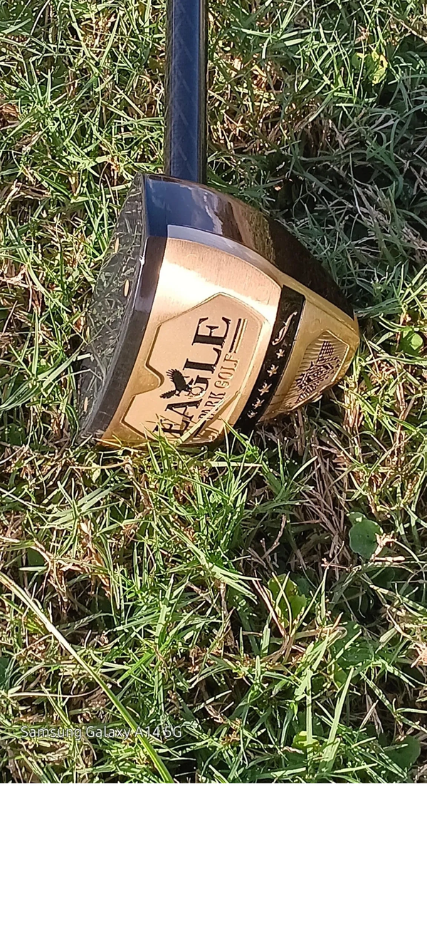 Close-up of an Eagle golf club on green grass outdoors.