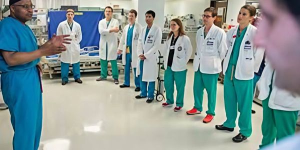 Medical team in a hospital setting listening to a senior doctor.