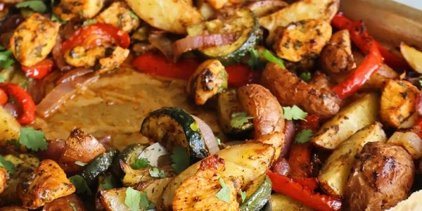 Close-up of seasoned roasted vegetables and chicken pieces.