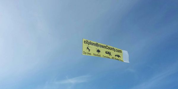 A yellow banner advertising exploreBrownCounty.com flies in the clear blue sky.