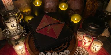 Mystical altar with candles, symbols, and a book in dim light.