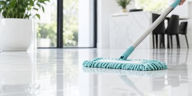 Cleaning a shiny tile floor with a mop.
