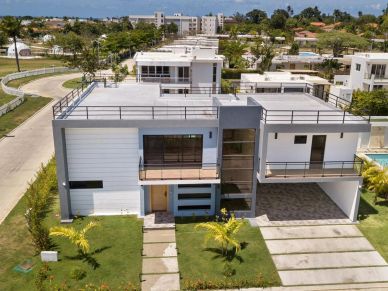 Modern two-story house with large windows and rooftop terraces.