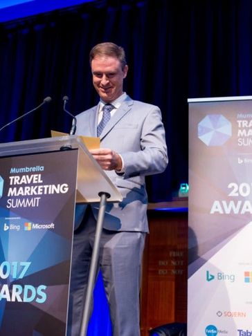 Christian Schweitzer on stage at Mumbrella Travel Marketing Summit and Awards