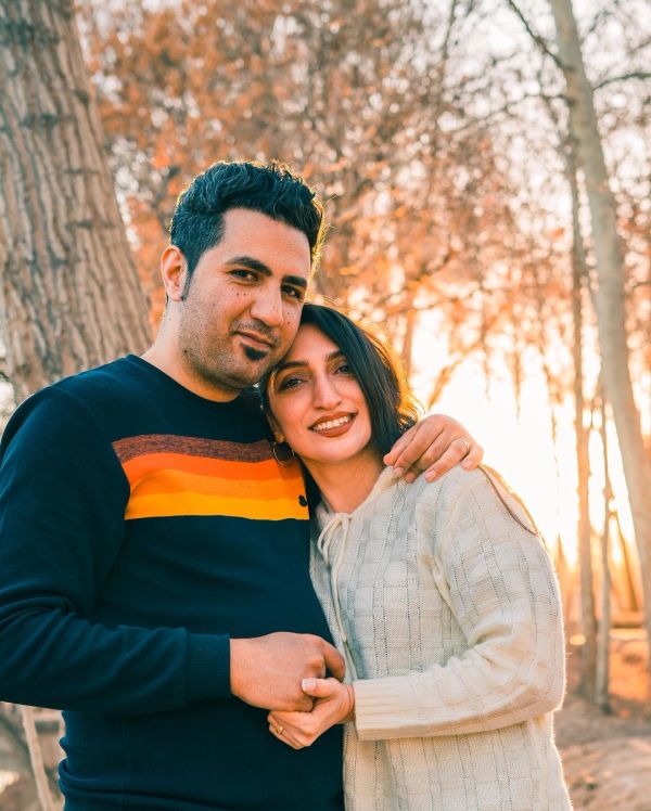 Couple embracing outdoors during sunset.