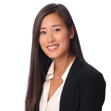 Professional woman in black blazer smiling confidently.