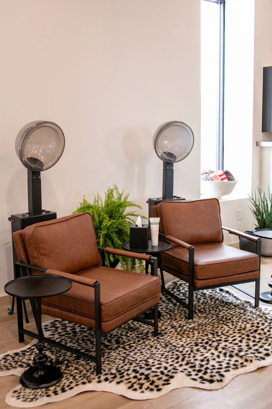 Client lounge with leather chairs and hooded dryers