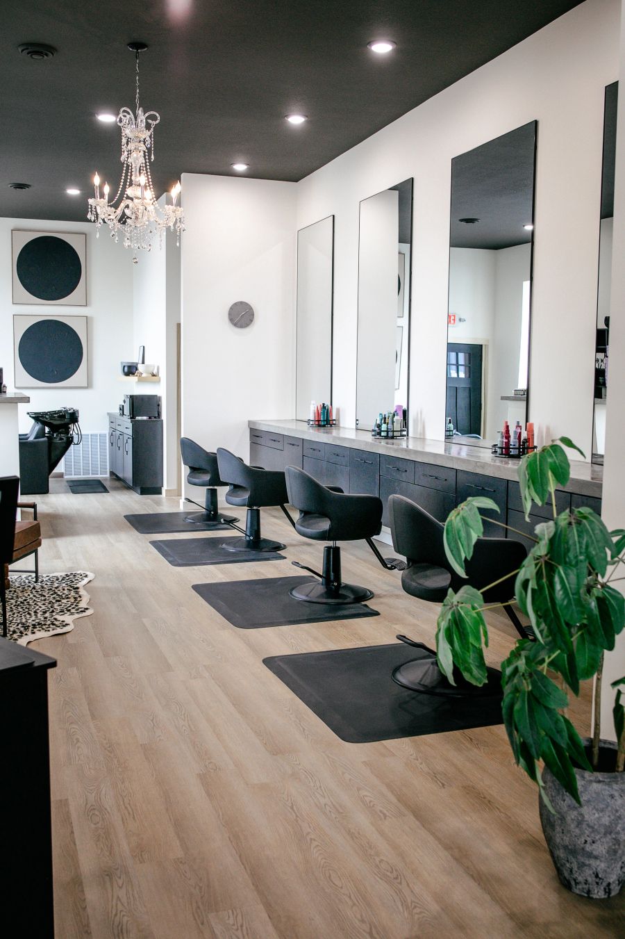 Styling stations under chandeliers at STYLE Hair Salon