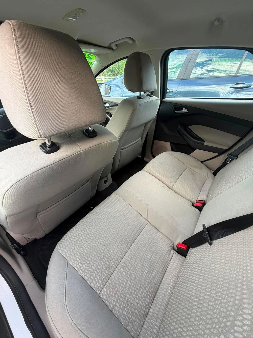 Clean beige car interior with spacious back seat.