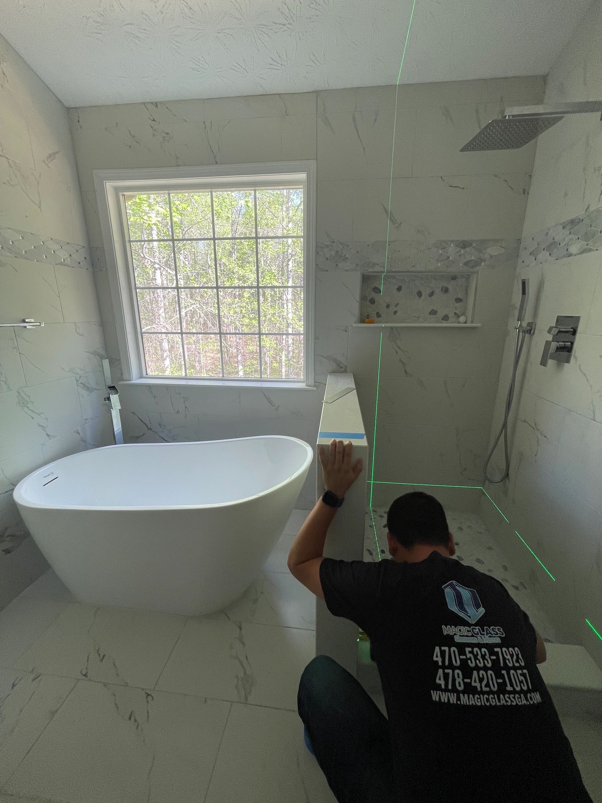 Owner measuring a bathroom for shower glass installation
