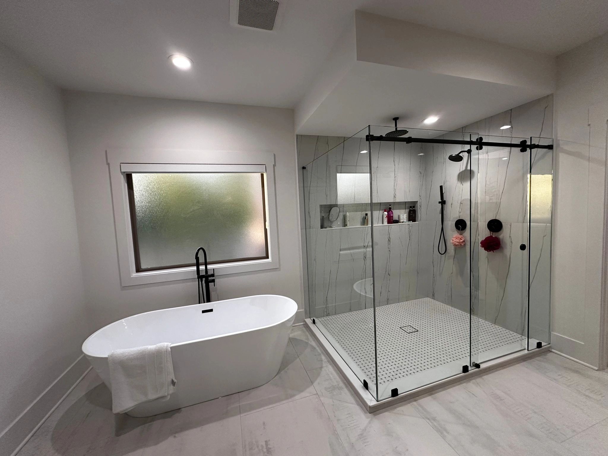 Shower glass panel and door with a tub on the left side