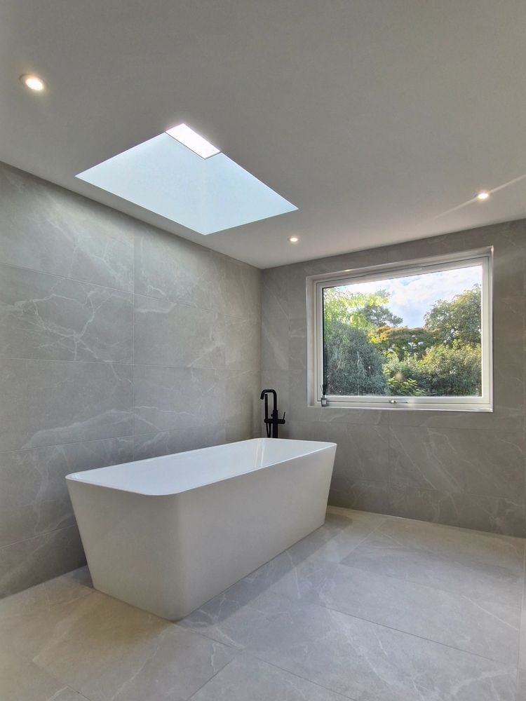 Modern bathroom with a freestanding tub and skylight.