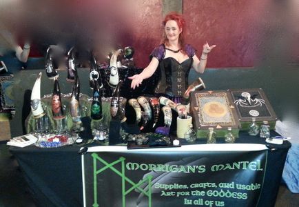 Woman stands behind a craft table with horns and books.