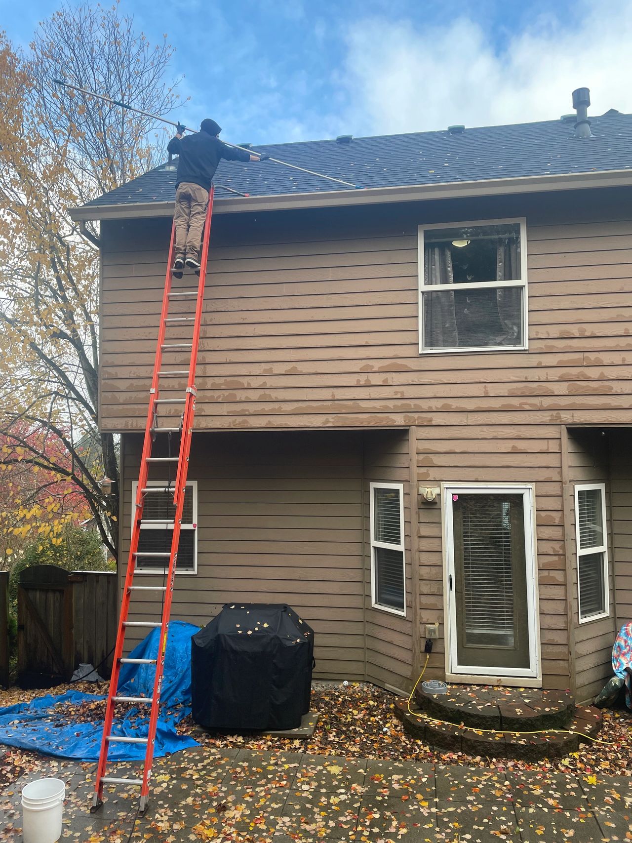 Using the ladder, ladder stabalizers, telescopic pole, gutter scraper to clean gutters safely