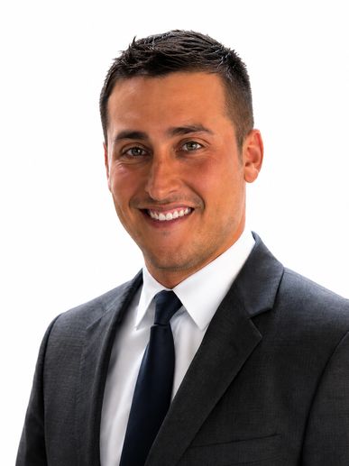 Smiling man in a dark suit and tie.