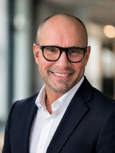 Smiling man wearing glasses and a suit.
