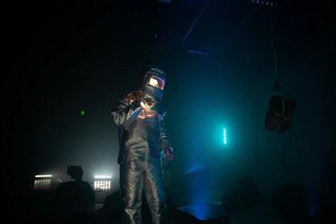 Astronaut working in a dimly lit industrial setting.