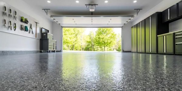 Clean, organized garage with tool storage and open door to a green yard.