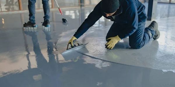 Worker applying epoxy floor coating.