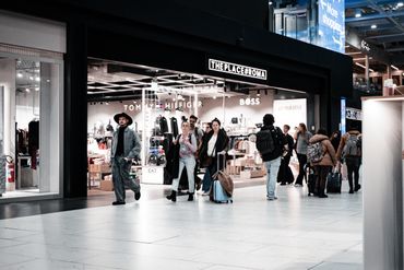 People walking in a shopping mall near a Tommy Hilfiger store.