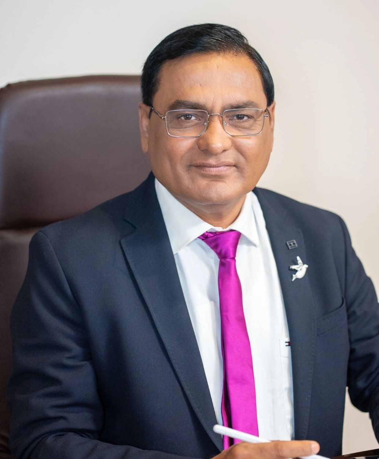 Professional man in a suit with a bright purple tie and glasses.