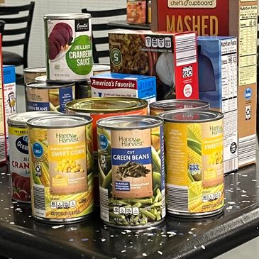 Assortment of canned vegetables and cranberry sauce on a table.
