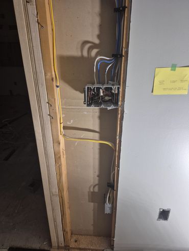 Exposed electrical wiring inside a wall under construction.