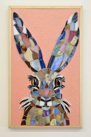 Mosaic artwork of a colorful rabbit on a pink background.