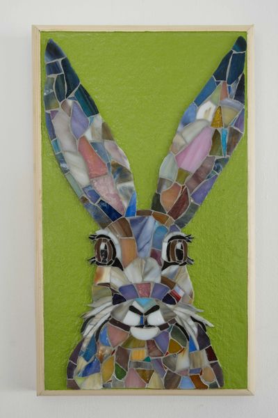 Colorful mosaic rabbit portrait on green background.