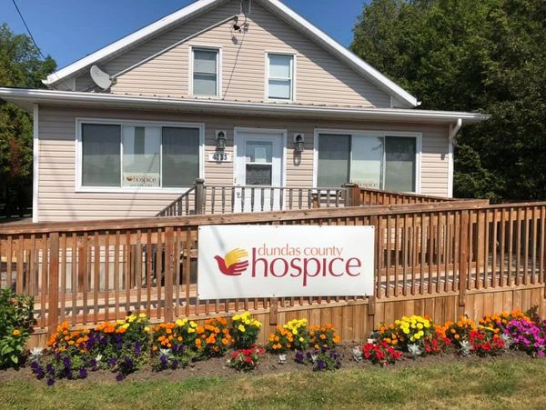 Picture of the front of the Hospice in summer with flowers.