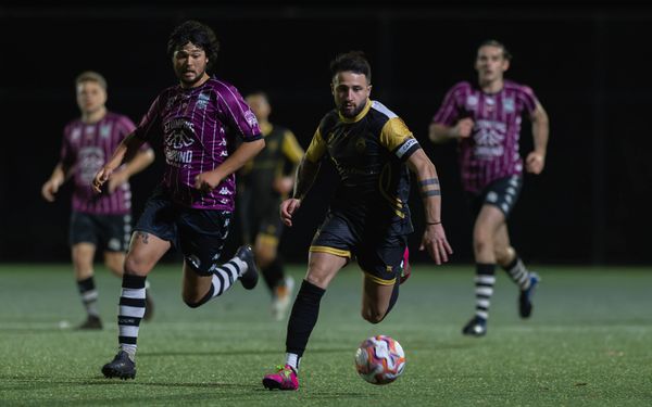 Two soccer players competing intensely for the ball during a night match.
