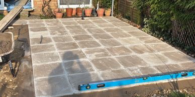 Newly laid concrete slab patio with a level tool on the edge.