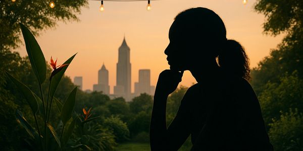 Silhouette of a woman contemplating at sunset with city skyline in the background.