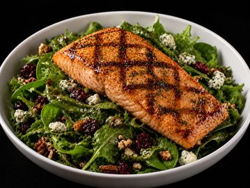 Grilled salmon on a fresh spinach salad.