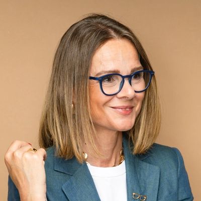 Woman with glasses smiling confidently.