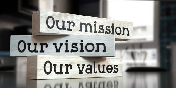 Three stacked blocks each with a separate phrase written. "Our Mission" "Our Vision" "Our Values"