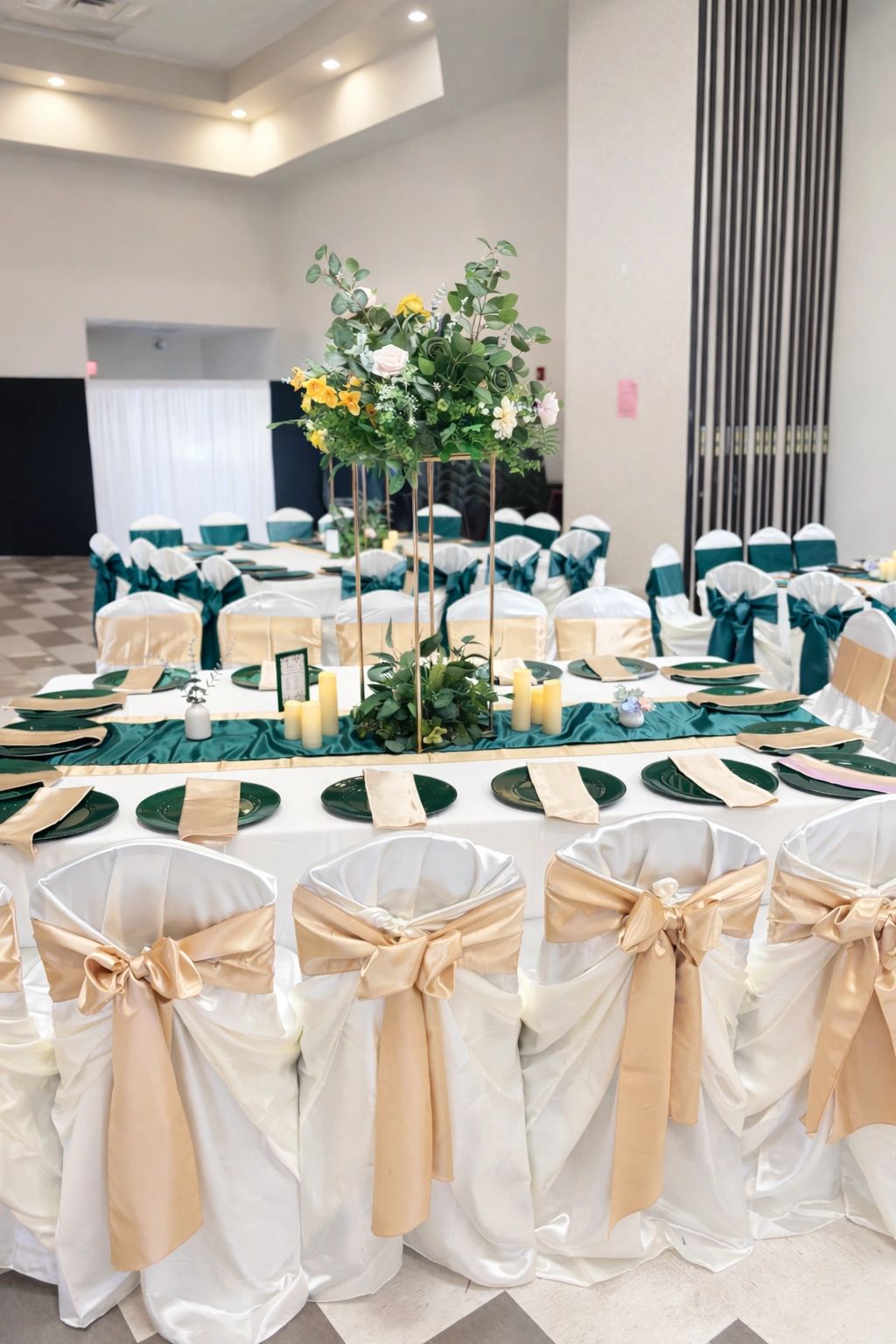 Premium event reception décor in Calgary featuring white chair covers with gold bows, elegant emeral