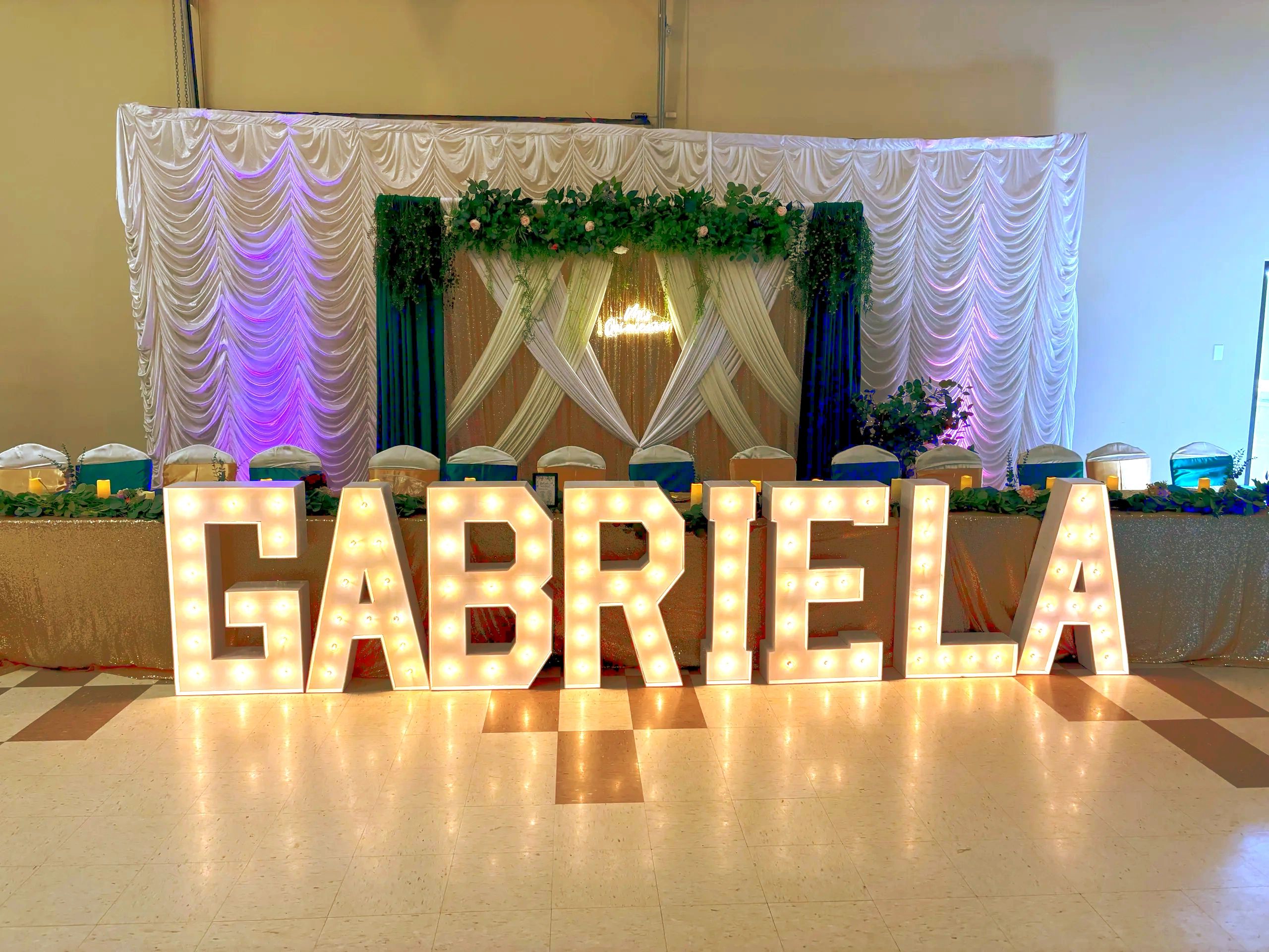 Luxury quinceañera backdrop with draping, greenery and marquee letters - Calgary, AB.
