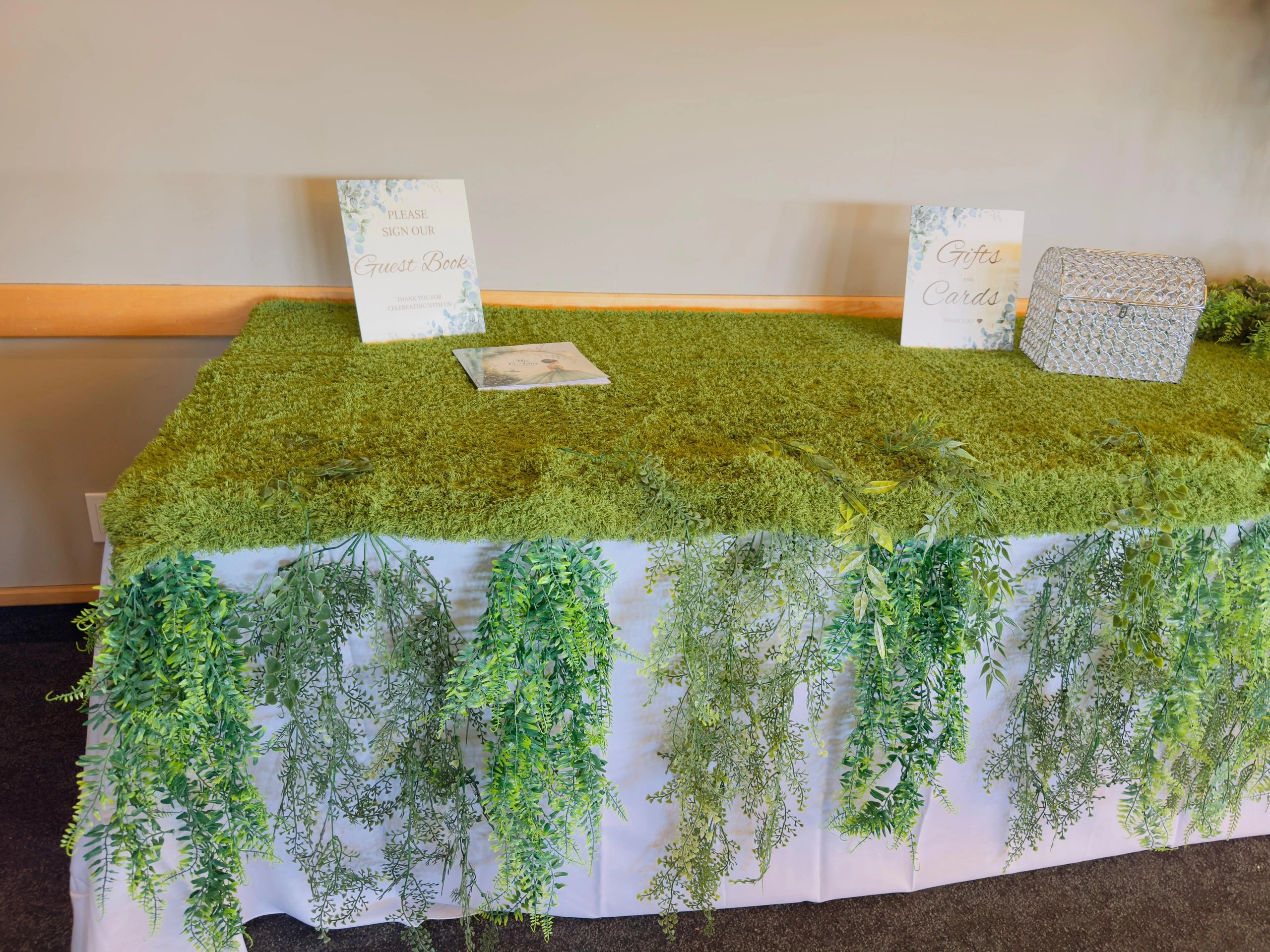 Premium event table styling in Calgary featuring a lush greenery-covered table with cascading foliag